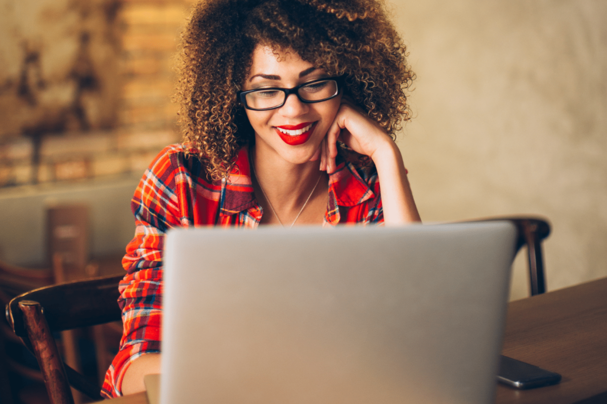 blogger smiling because she is making money blogging on laptop